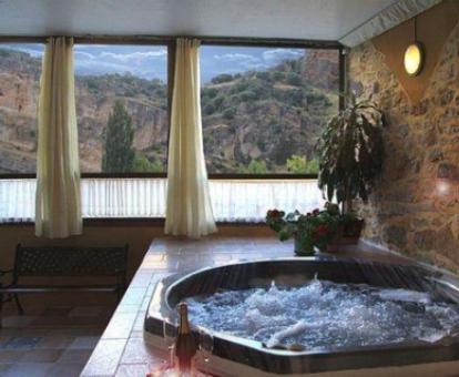 Precioso spa con jacuzzi y vistas a la naturaleza de este establecimiento.