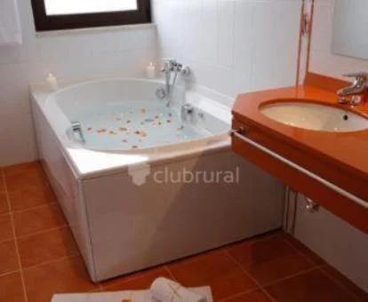 Baño con bañera de hidromasaje privada de la habitación con cama grande.