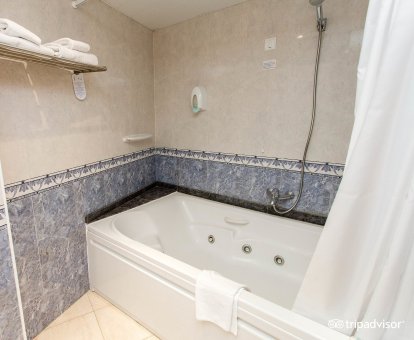 Bañera de hidromasaje privada en el baño de la suite con vistas al mar del alojamiento. 