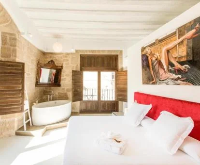 Una de las amplias habitaciones con bañera junto a la cama del hotel.