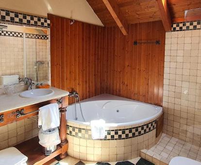 Baño con bañera de hidromasaje privada de la habitación doble Deluxe del hotel. 