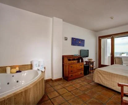 Habitación Doble Superior con vistas al mar y bañera de hidromasaje cerca de la cama.