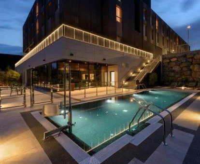 Piscina exterior de este hotel con encanto con una bella iluminación nocturna.