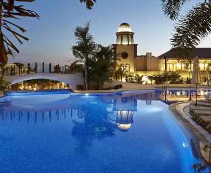 Zona exterior con piscina y una romántica iluminación nocturna de este hotel con encanto.