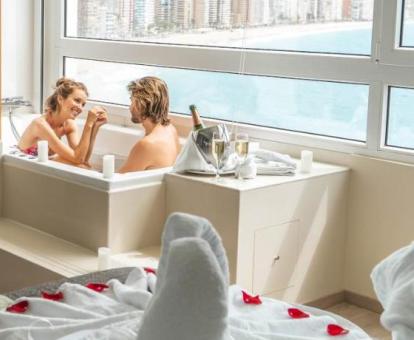 Pareja disfrutando de la bañera de hidromasaje privada de una de las suites con vistas al mar del hotel.