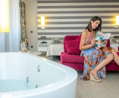 Bañera de hidromasaje privada junto a la cama en la Habitación Doble Deluxe con terraza del hotel.